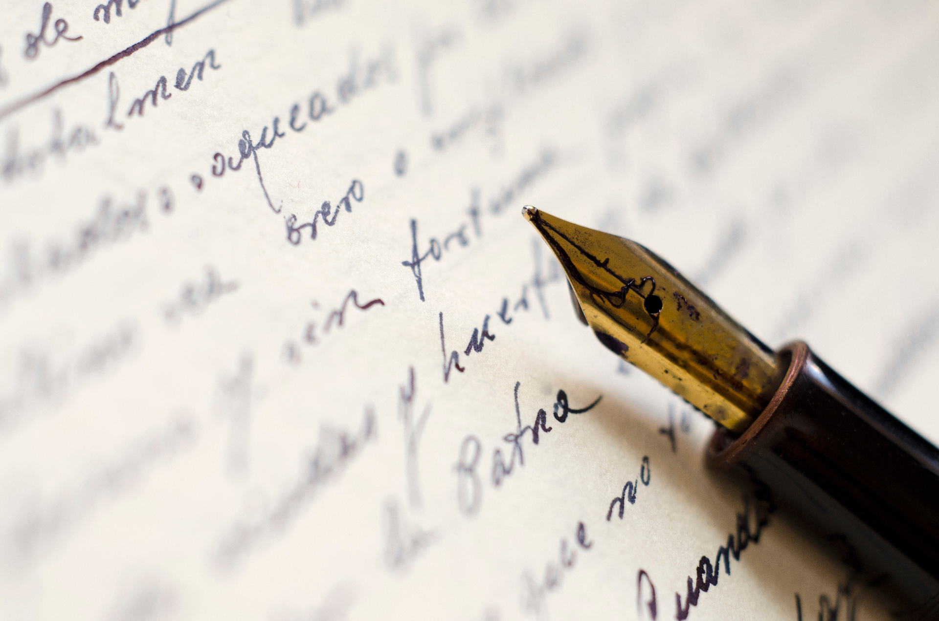 A fountain pen resting on handwritten paper, evoking crafted written insight.
