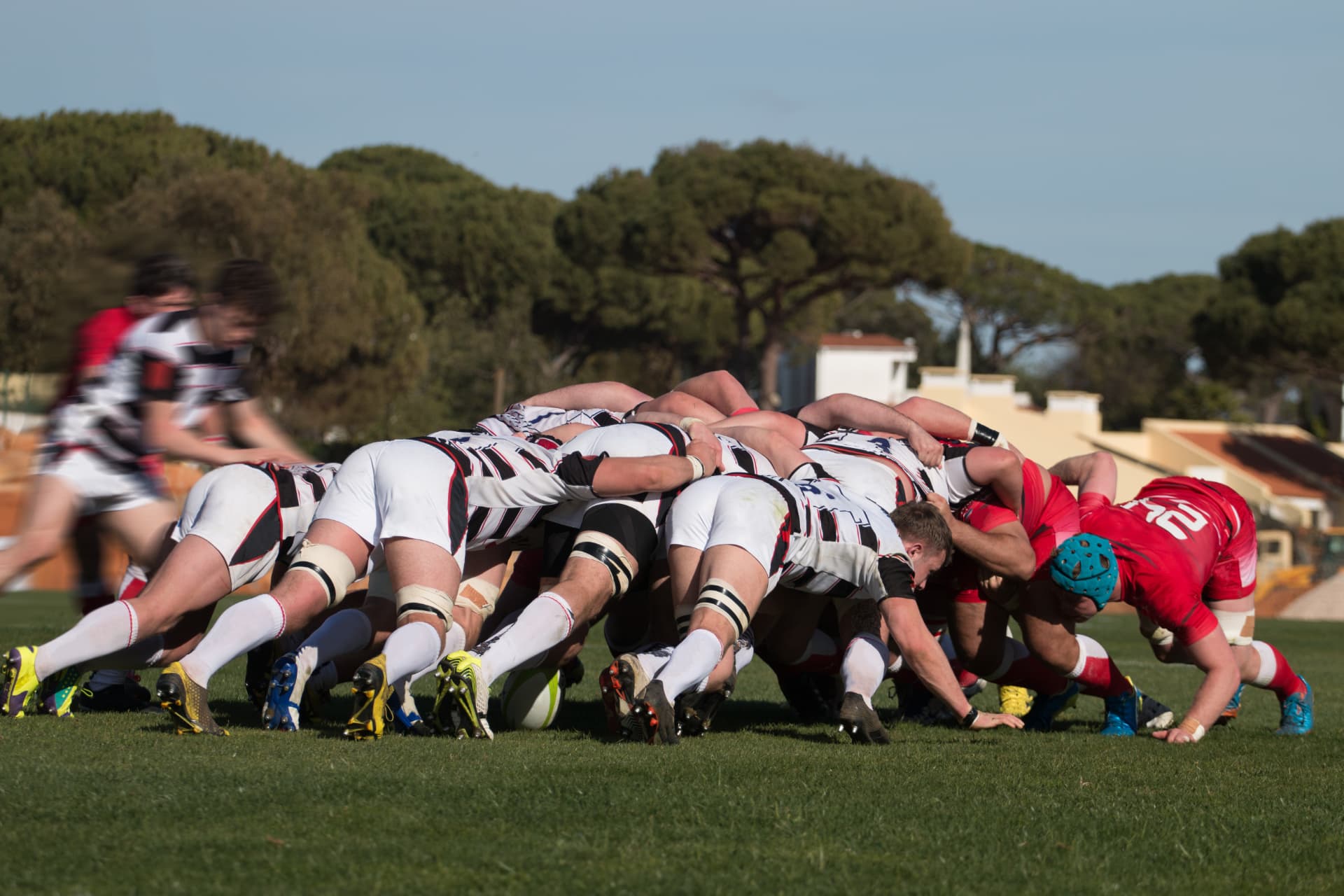 A rugby scrum pushing forward on a green pitch: elite sport's discipline of a few key metrics.